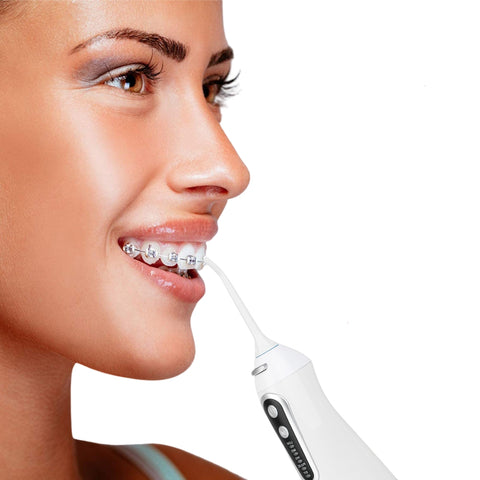 Smiling lady using an advanced water flosser that's better than Waterpik. Aqua Jet Refresh from WhiteWaveSmile