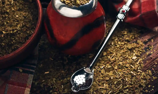 Bombilla en primer plano con mate y yerba de fondo