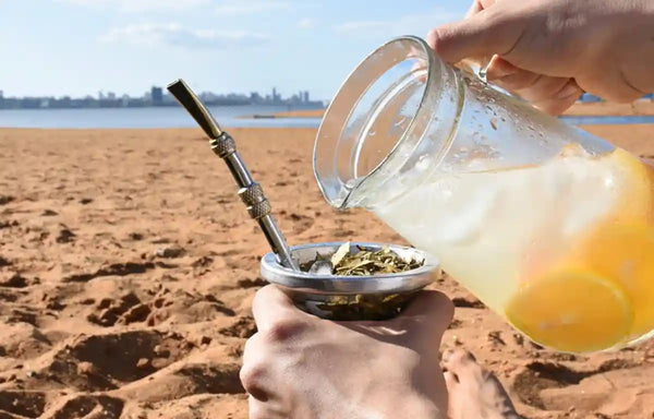 Persona bebiendo tereré en una playa