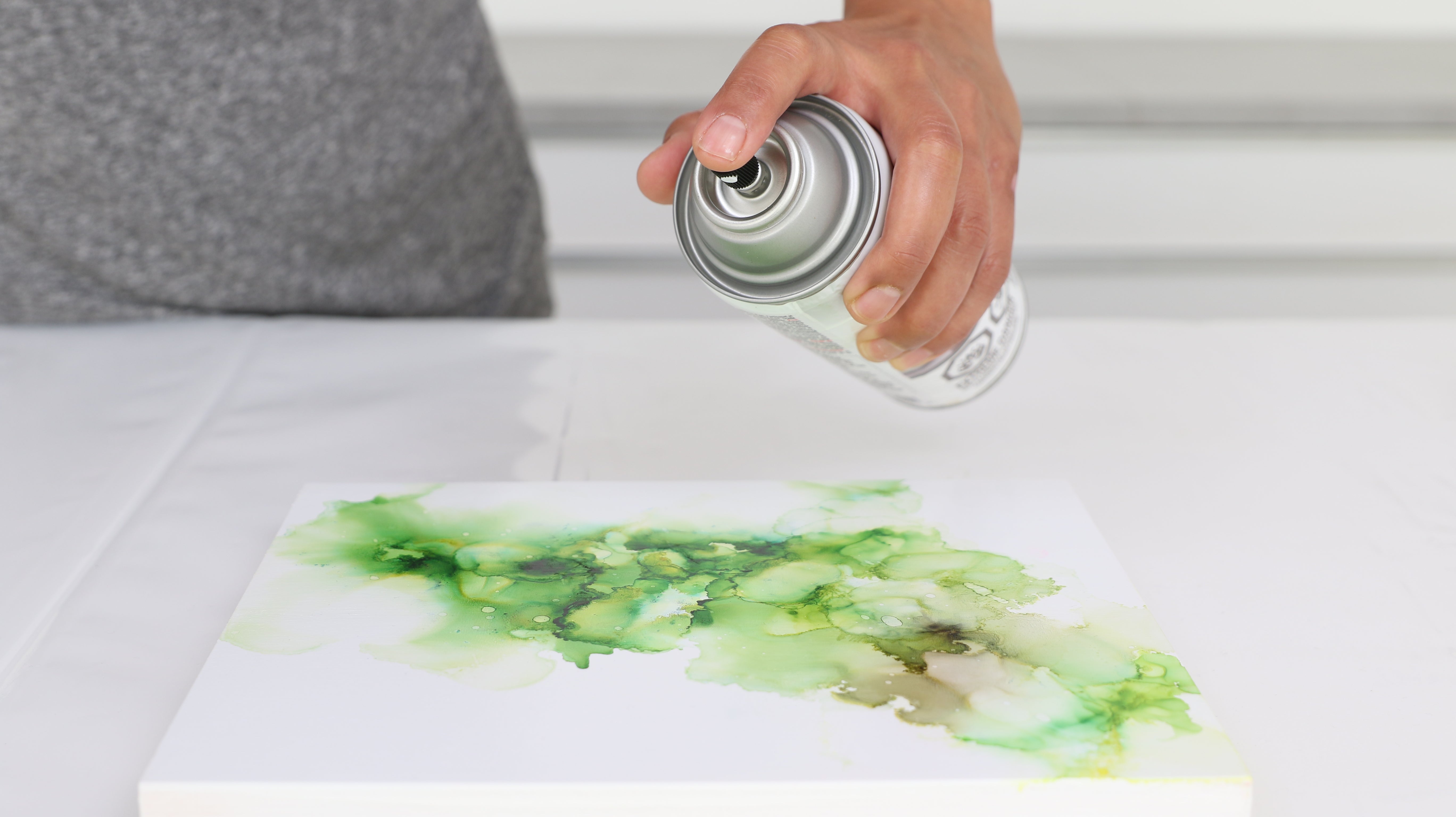 spraying sealant over artwork