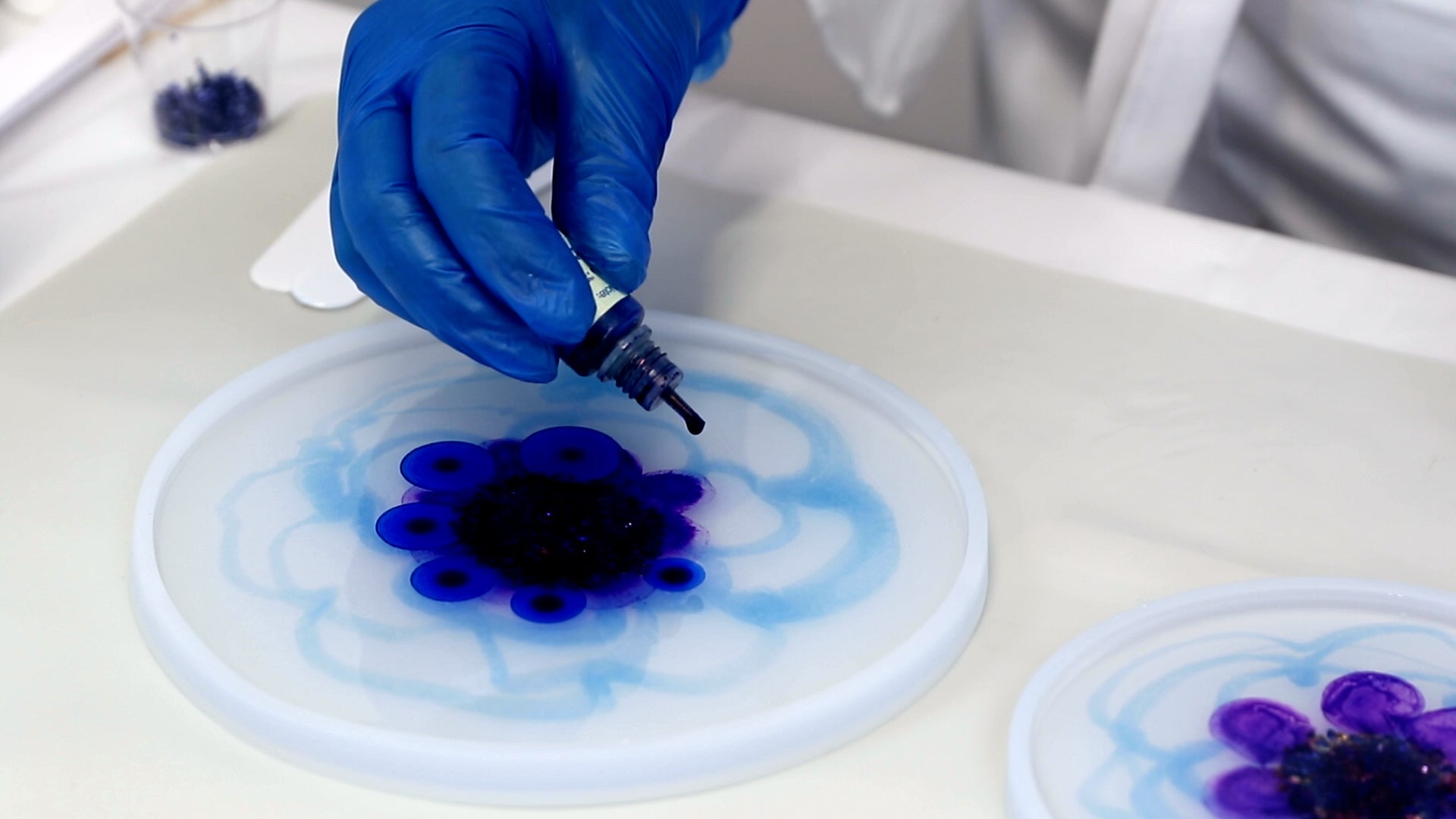 add blue alcohol ink drops in between the purple dots in resin