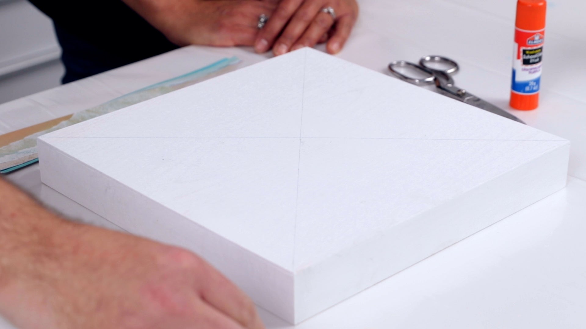 how to resin a paper collage: draw an X across the panel to find the center of the board