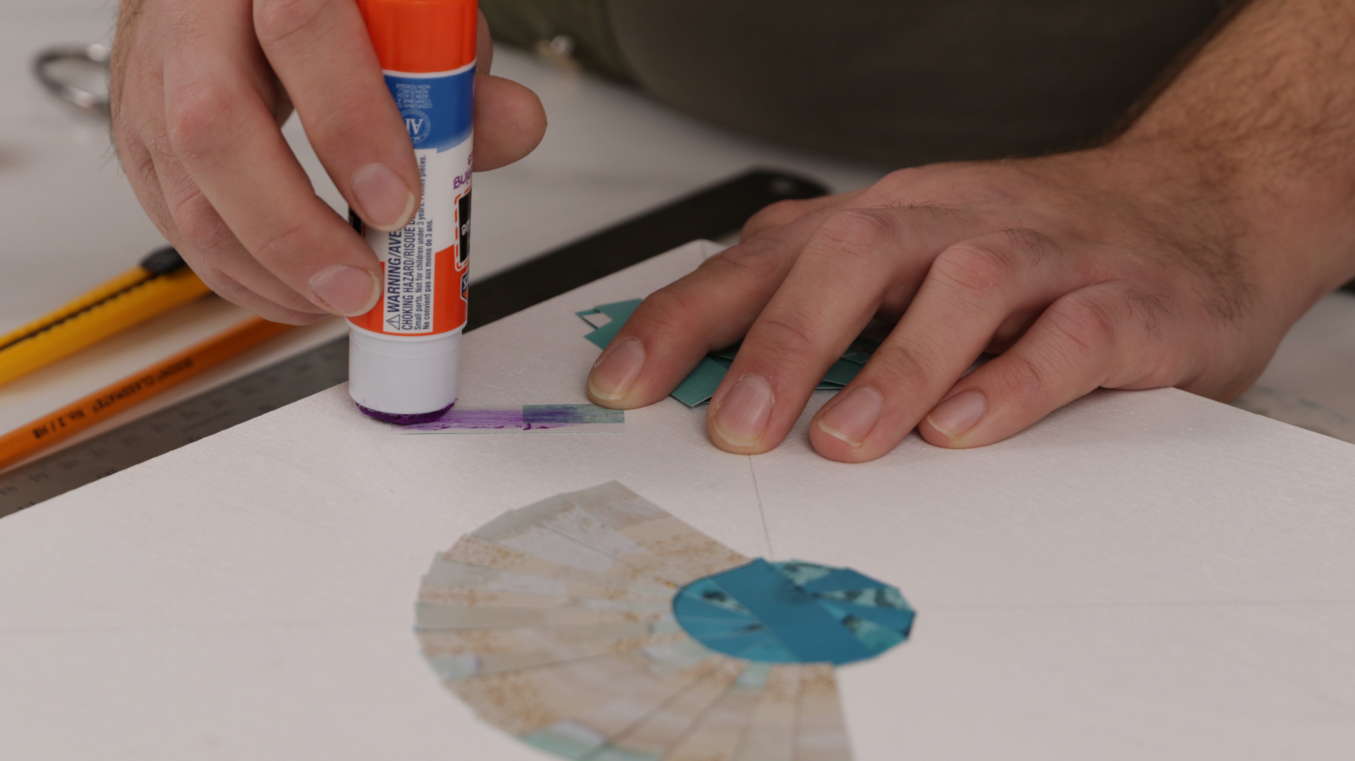 how to resin paper collage art: apply glue to strips and place onto the panel