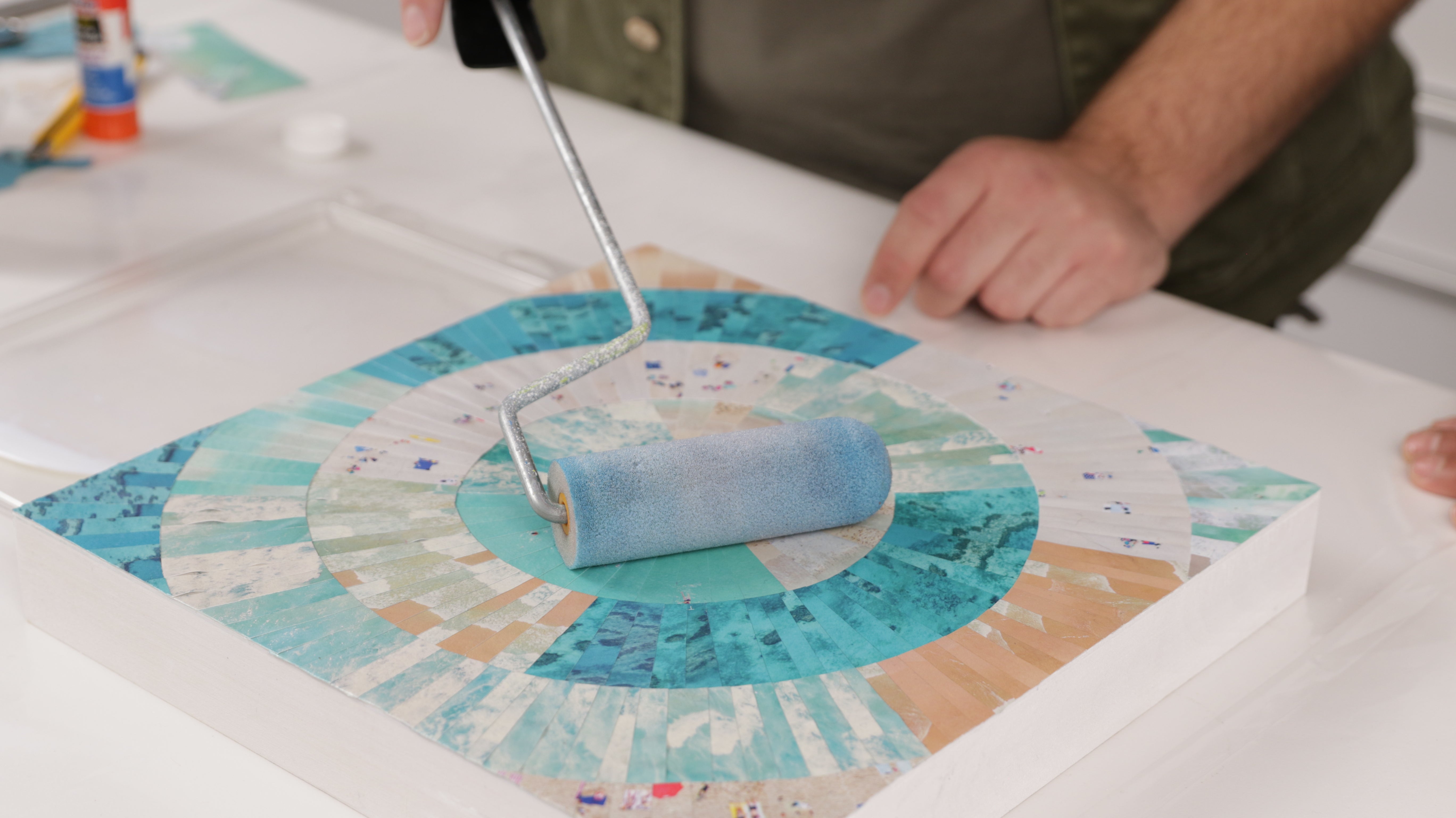 how to resin paper collage art: use a foam roller to apply sealant over the collage before applying resin