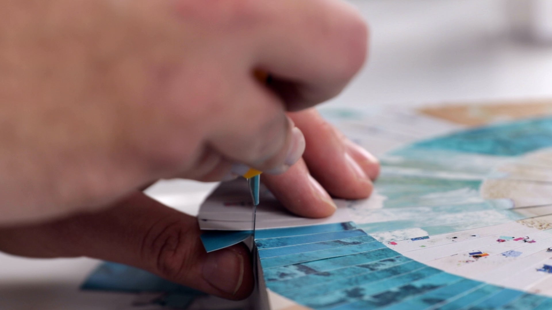 how to resin paper collage art: use your thumb as a guide to keep the blade flush against the side of the panel