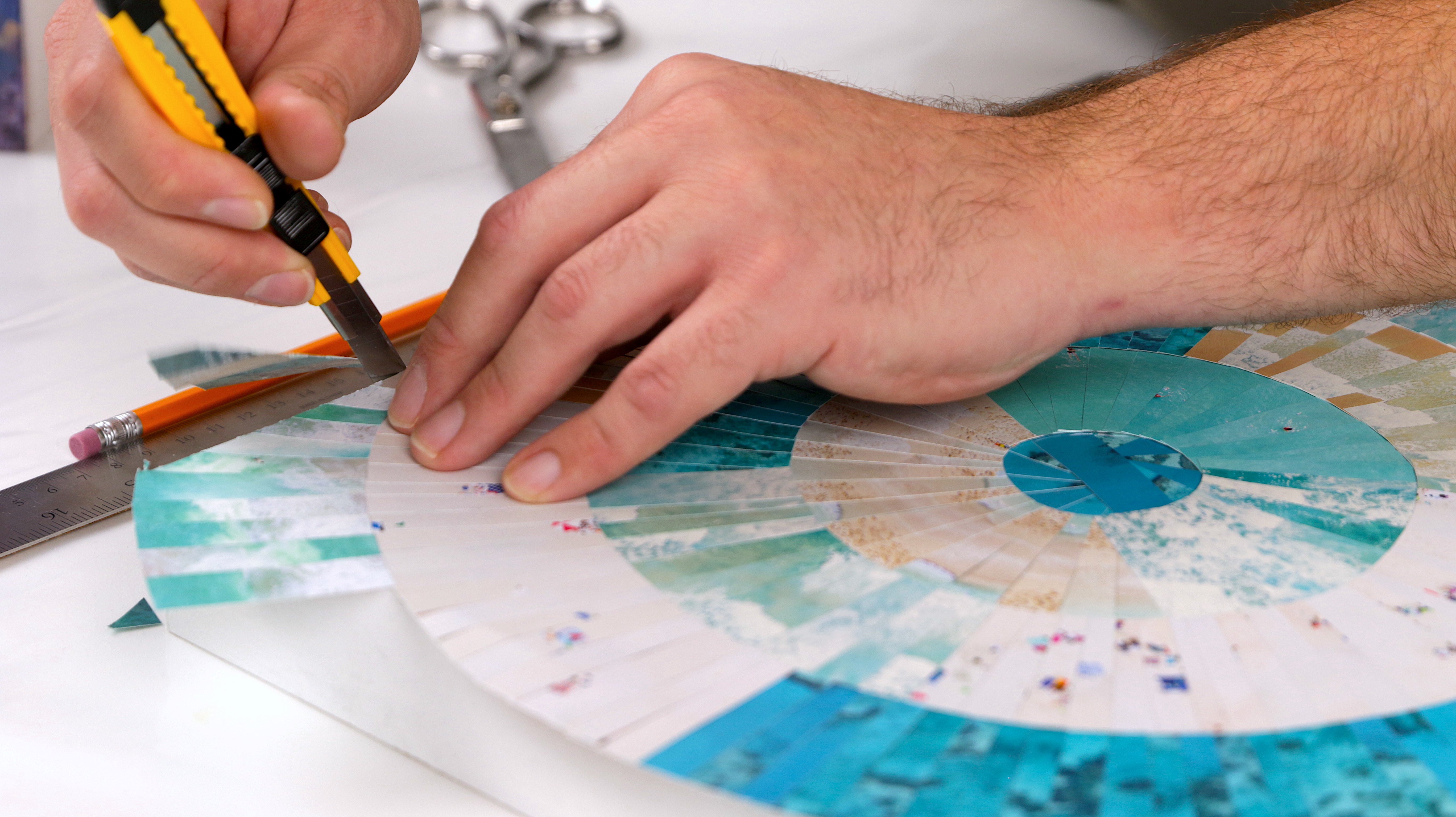 how to resin paper collage art: use a utility knife to trim off excess paper