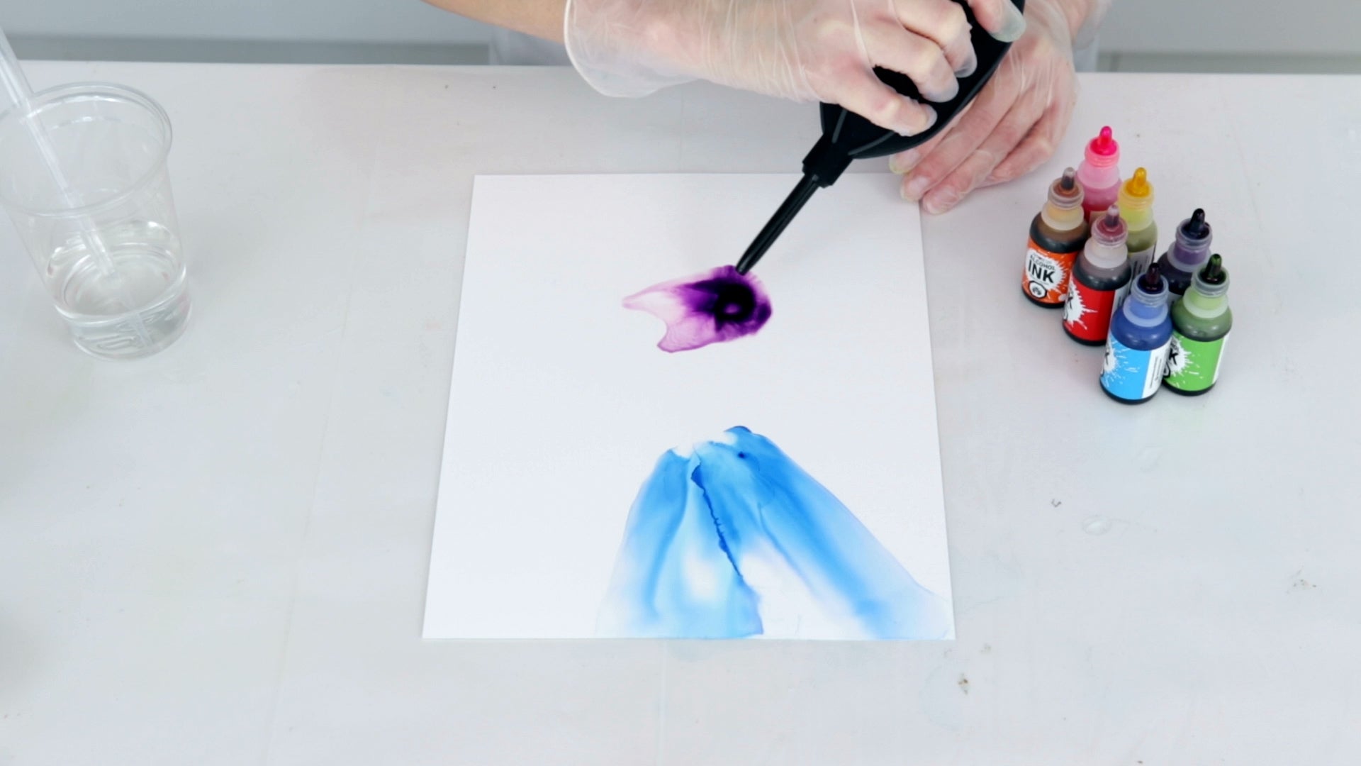 create a faded out look by blowing alcohol ink on yupo with a hand blowing tool