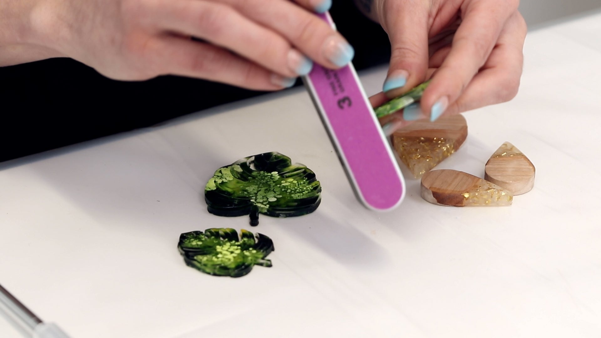 use a multi sided nail file to sand down rough resin edges