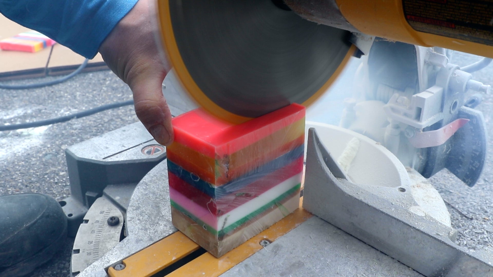 slicing square block of layered resin with chop saw