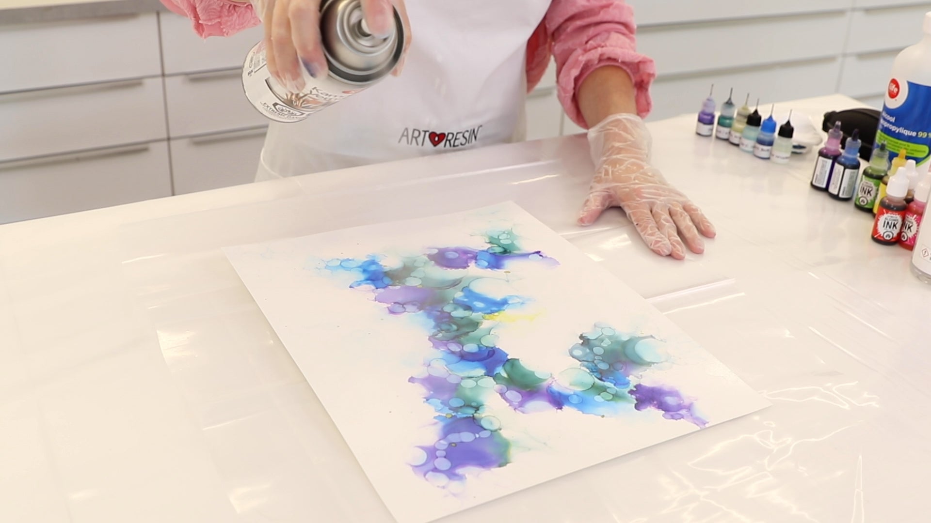 spraying varnish on alcohol ink abstract painting