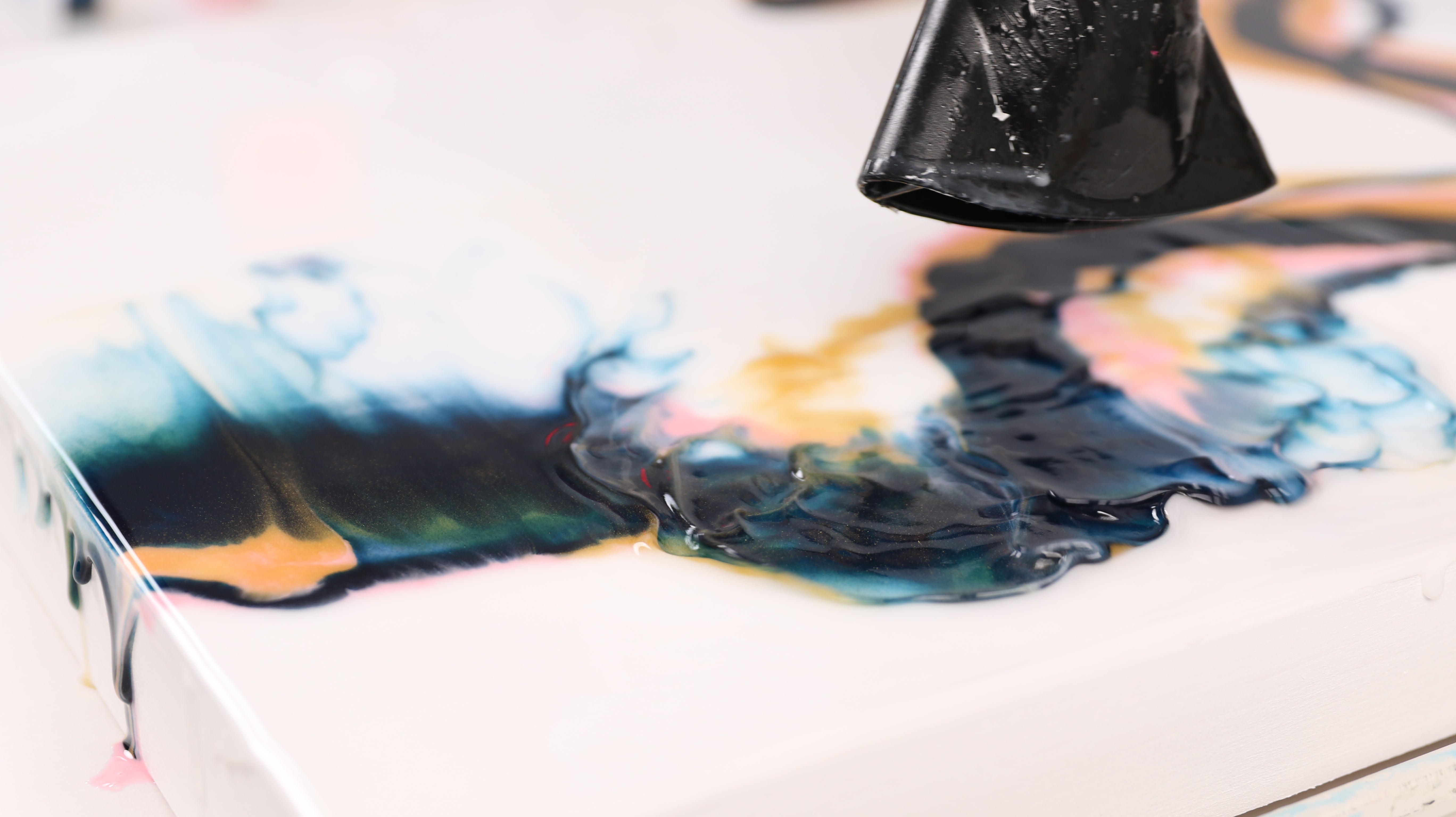use a blow dryer to blow the resin around to create dutch pour design