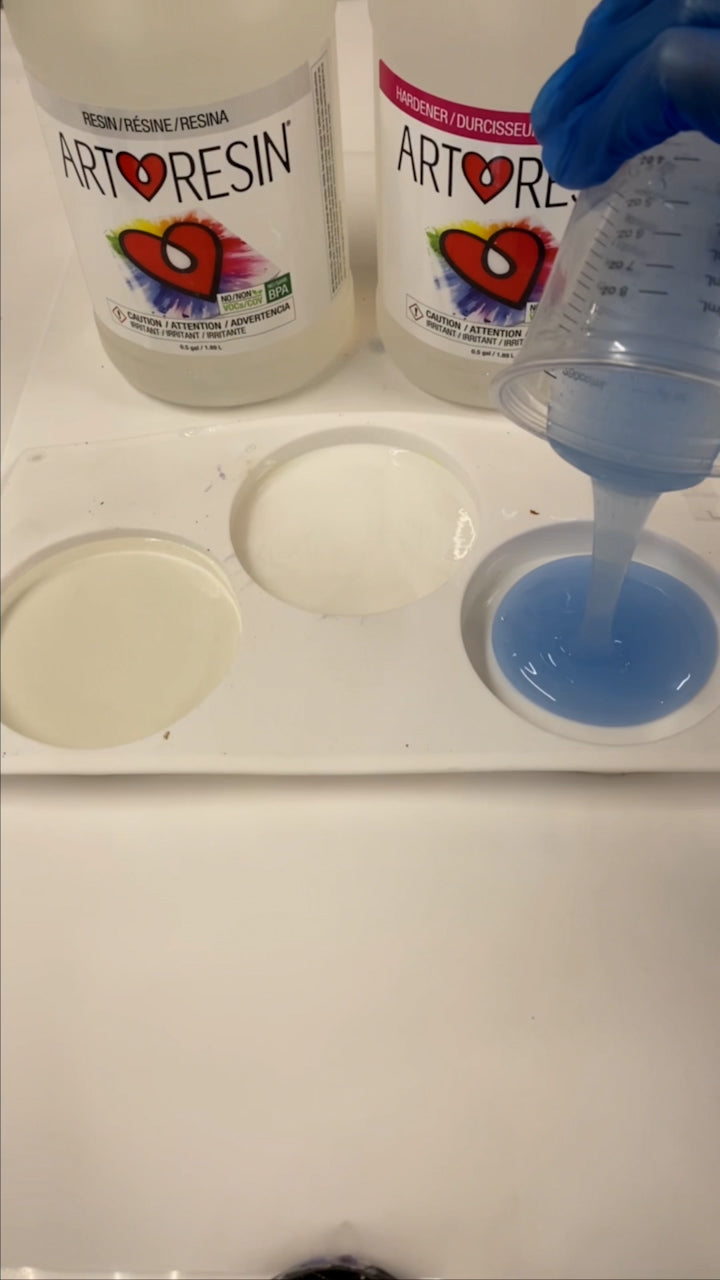 pouring blue tinted epoxy resin into silicone mold to make DIY coasters