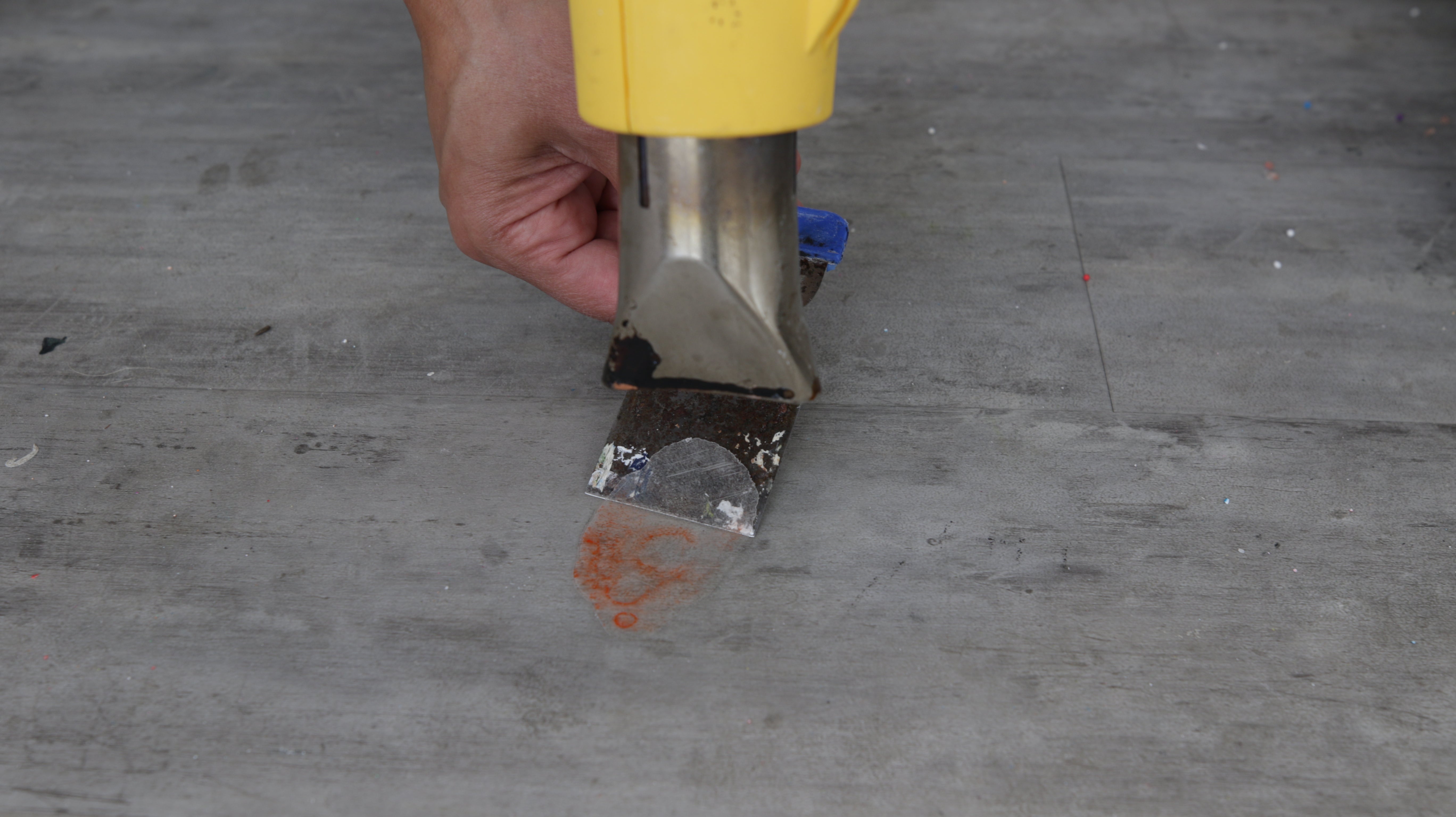 use heat gun and scraper to remove cured resin spill from floor