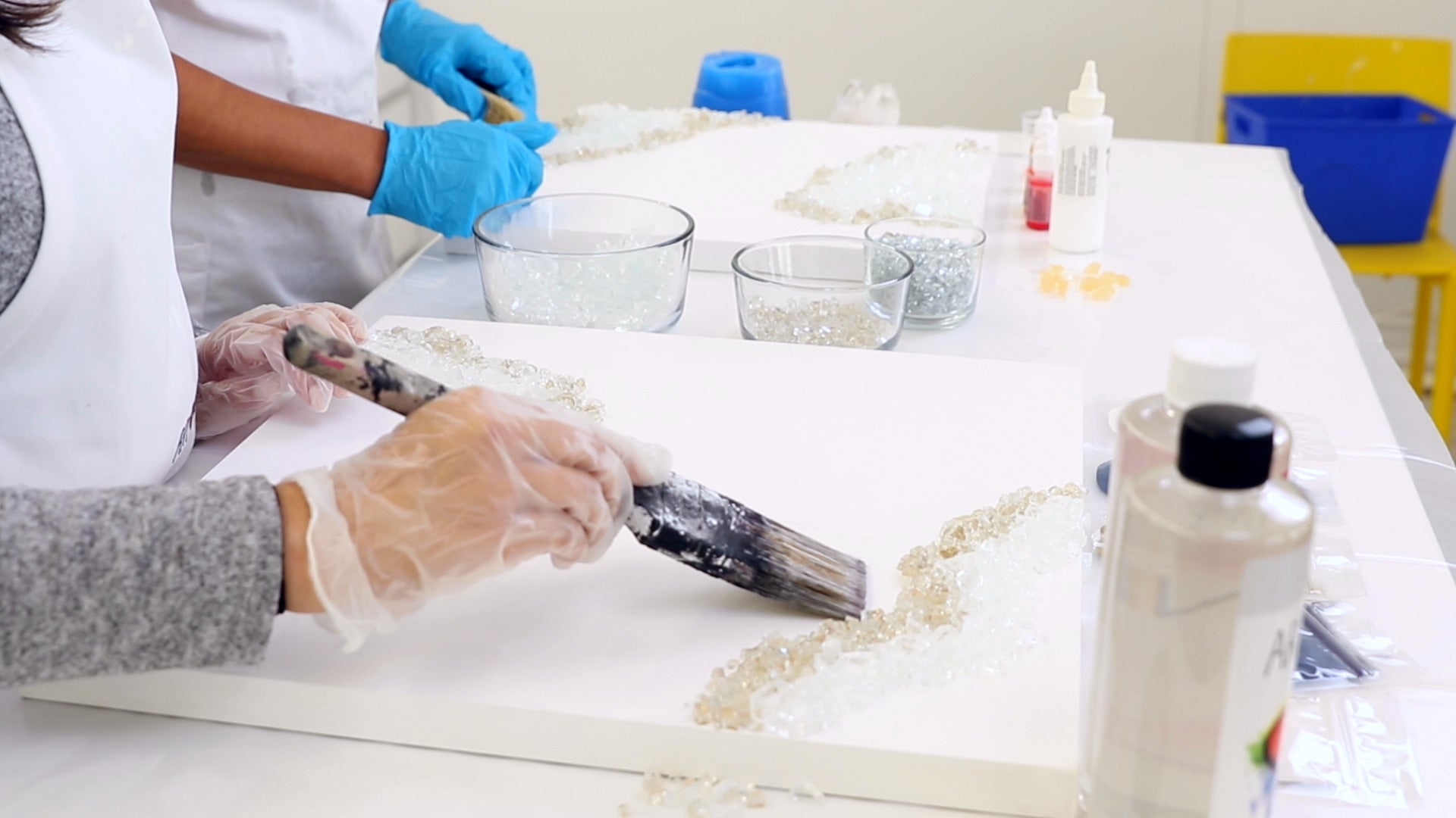 use wide paintbrush to move glass crystals on geode resin panel