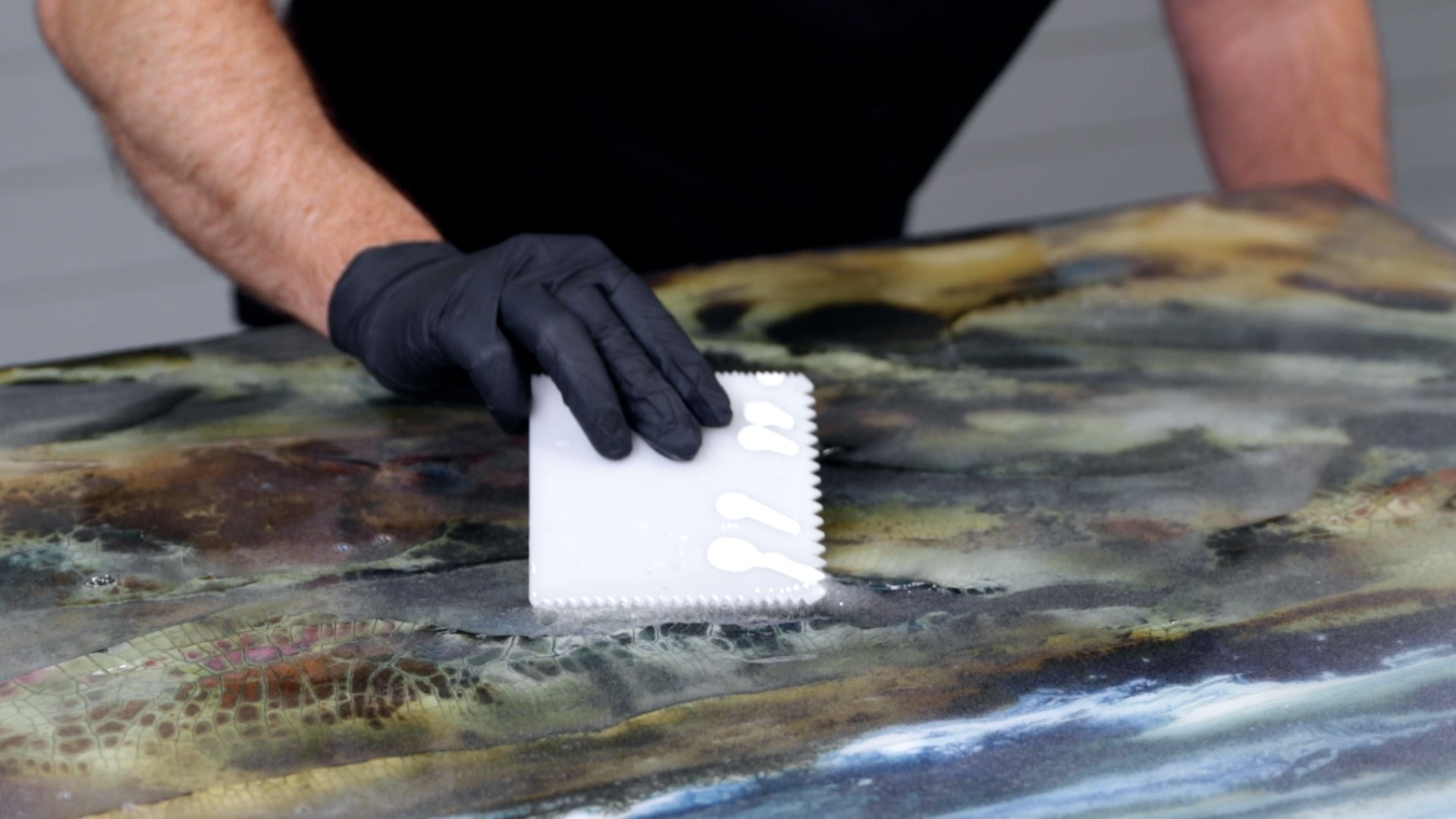 resin a large piece of art - use a spreading tool to apply resin quickly
