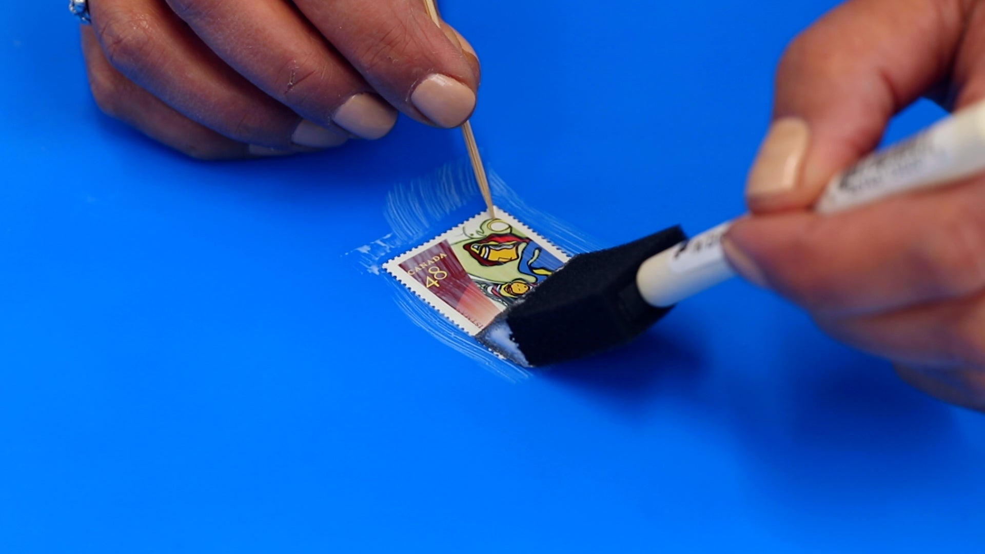 use a toothpick to hold artwork in place while you brush on a sealant