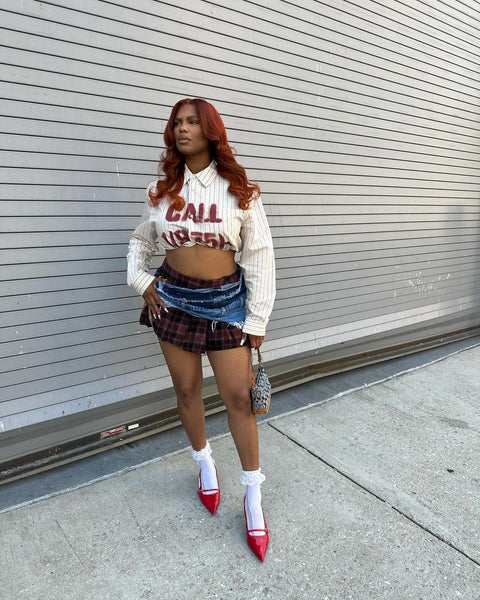 Model with custom colored dark red hair wearing plaid and denim skirt and long sleeve crop top