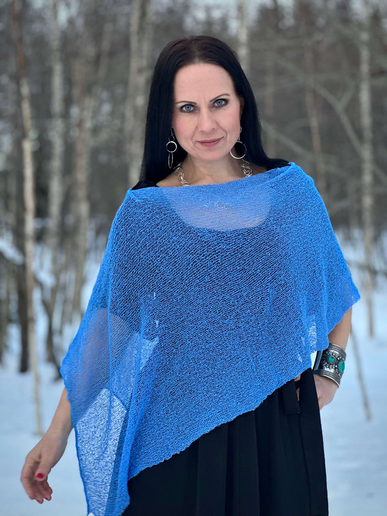 Blue Ulla Jacobsson Ella cape on model with dark hair standing outside in the snow.