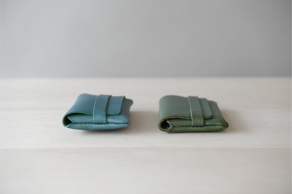 Business card holder made of blue green leather material, card case changes over time, thickness remains the same, the right one has been used for about 2 years.
