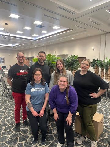 TTMT employees at the Cedar Valley Hospice posing and smiling after setting up for the auction