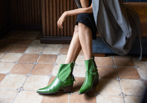 lady wearing black tulip green ankle boots