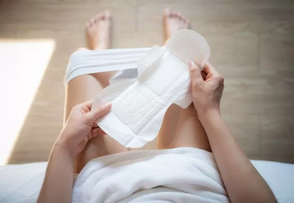 a women is in toilet with a sanitary pads