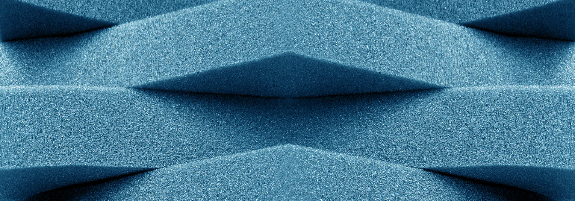 Close-up of blue, textured, pyramidal-shaped acoustic foam.