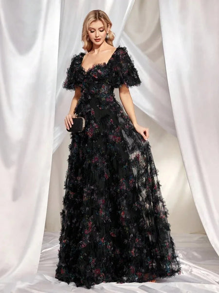 a woman posing in a black floral long dress