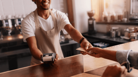 Customer making a purchase in a coffee shop attributed to revact media content marketing.