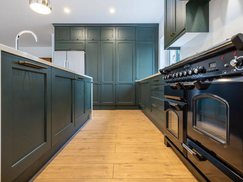 green kitchen cabinets with bronze handles and stainless steel tap