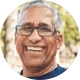 Smiling man with glasses and white hair.