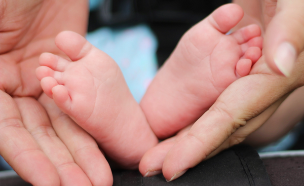 Baby feet and mums hands