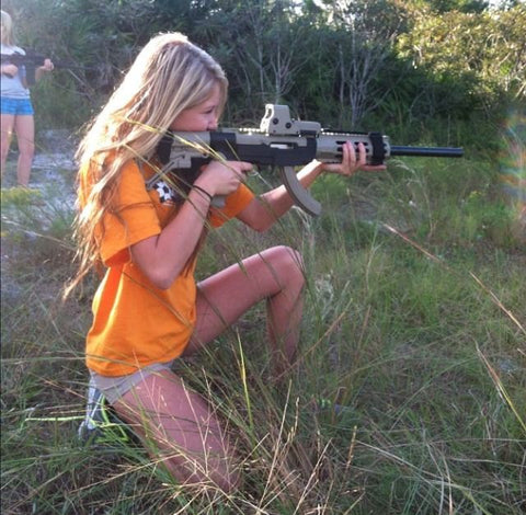 Confident girl shooting rifle