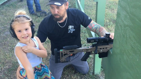 Little girl smiling after learning to shoot a rifle