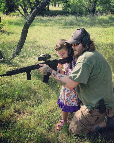 Father and daughter shooting rifle