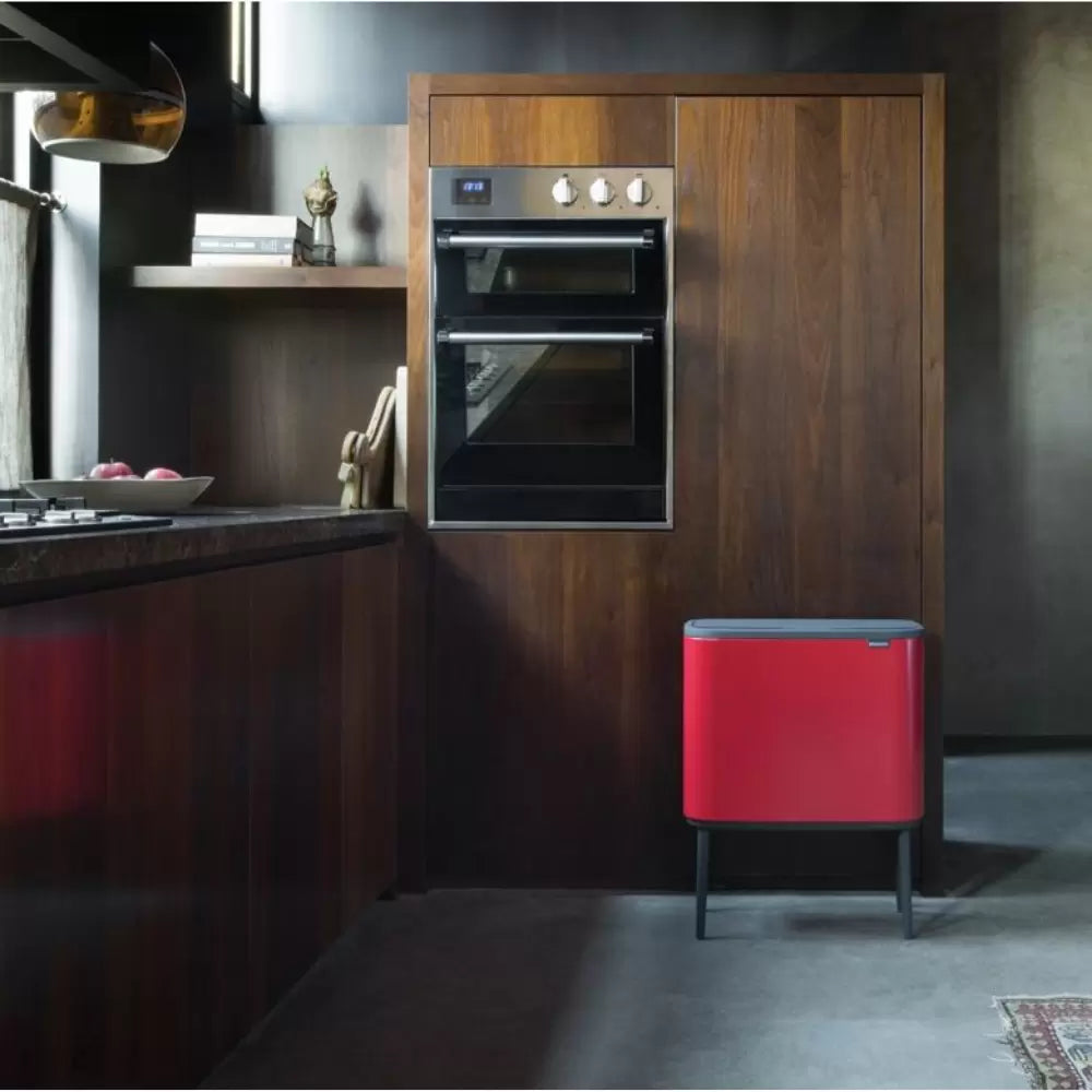 A red Brabantia bin in dark kitchen