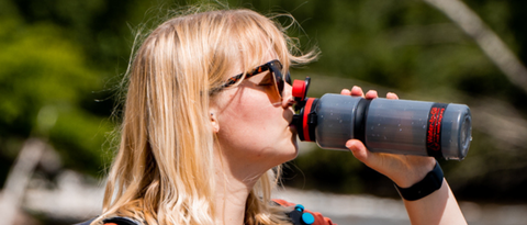 Blond woman in sunglasses drinking from Water to Go Active water filter bottle
