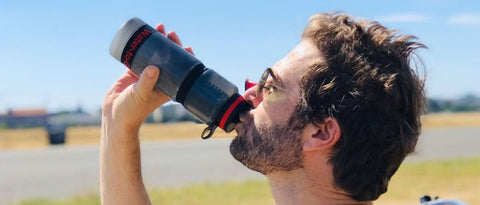 Man in sunglasses drinking from water filter bottle