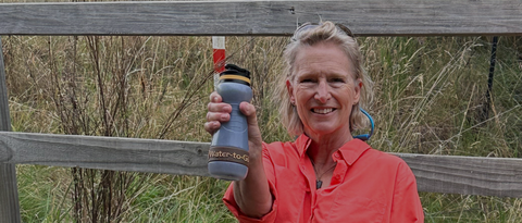 Woman in red shirt holding Water to Go Bioplastic water filter bottle