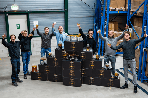 Whisiskey team cheering in front of collection of whiskey decanters