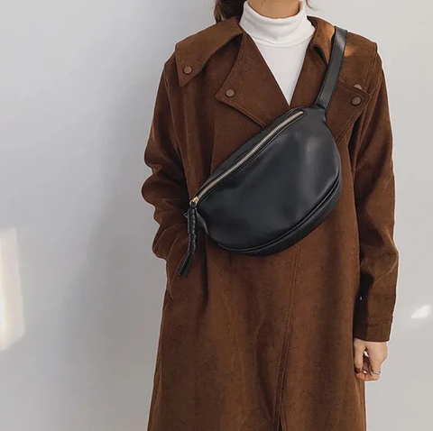 Femme avec manteau marron portant sac banane xxl noir