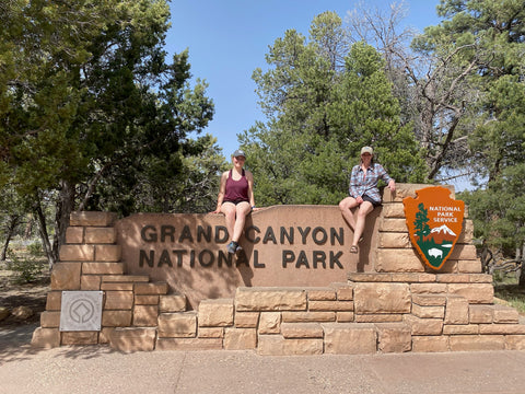 women on grand canyon national park sign