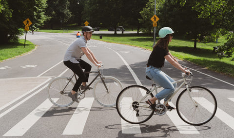 Safe Riding | Two people on bicycles with helmets