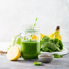 Glass of green smoothie with banana lemon  spinach