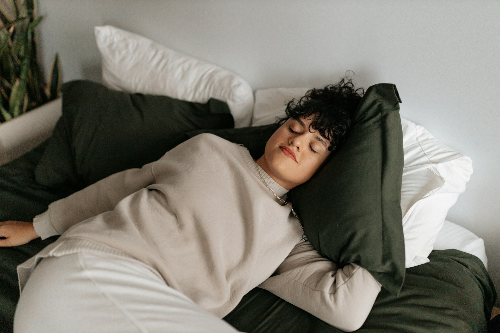 Sleeping dark-haired woman wearing a beige outfit