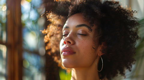 a beautiful woman with curly hair. Her eyes are closed and she looks very peaceful.