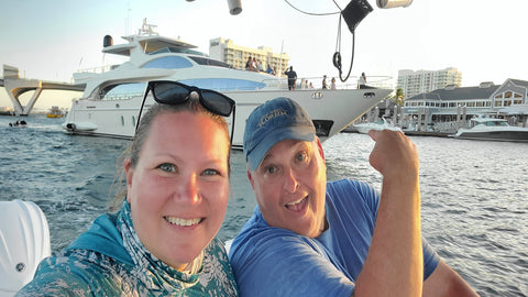 katie and bob on the DeadFishSociety 24 foot Sportsman CC with a huge yacht behind them