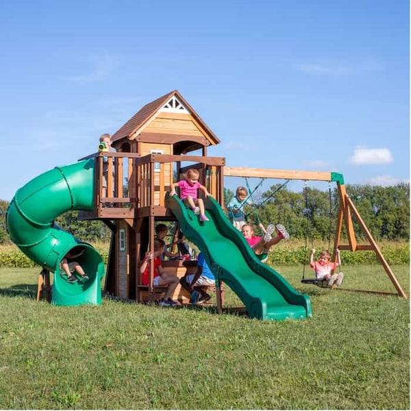 Multiple kids playing on a large Backyard Discovery wooden swing set.