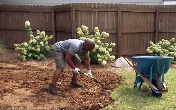 A man preparing the ground for a swing set.