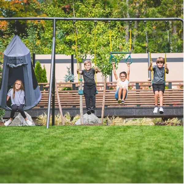 Four kids on a metal swing set.